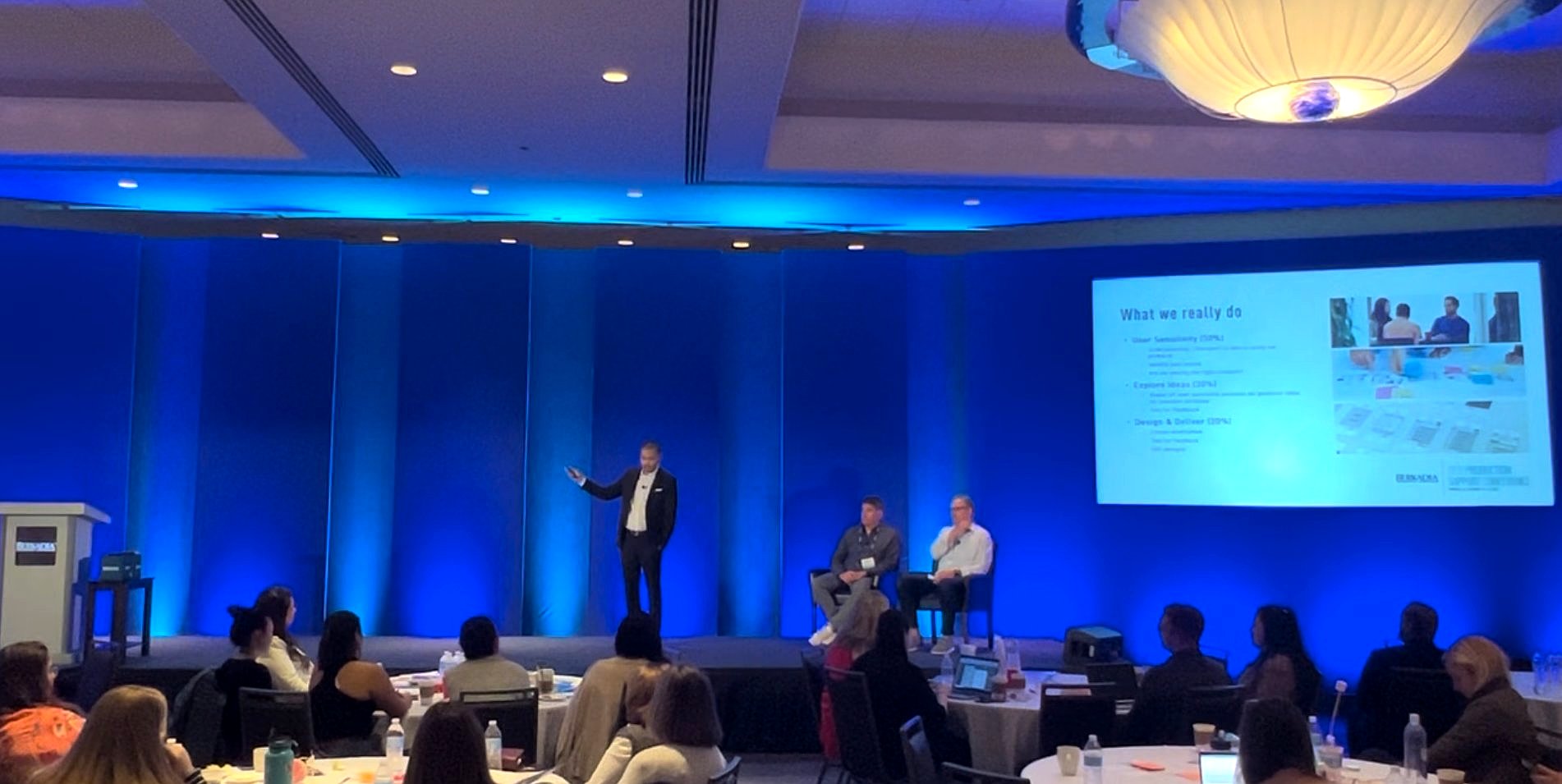 Elias Sipin presenting on stage at Berkadia conference with executives and audience